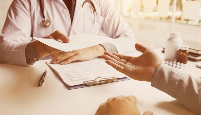 Arztbrief Ein Arzt überreicht einen Arztbrief an den Patienten.