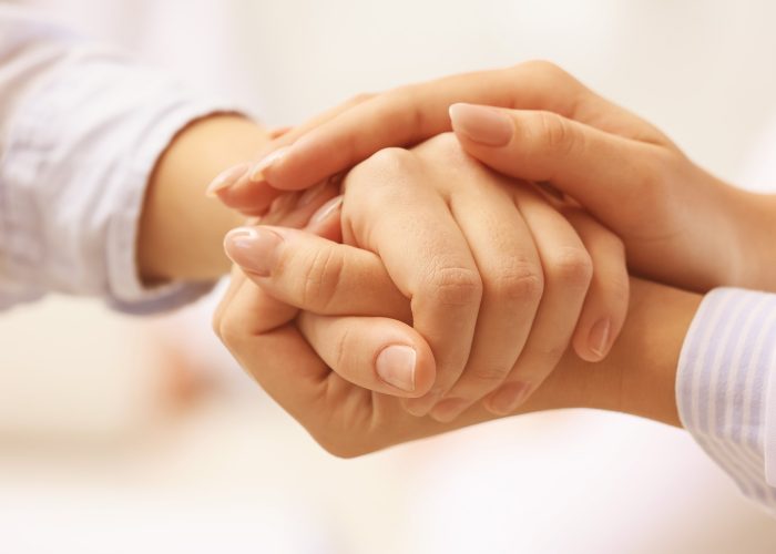 Arzt hält Hände Arzt hält die Hand eines Patienten.
