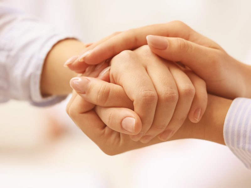 Arzt hält die Hand eines Patienten.