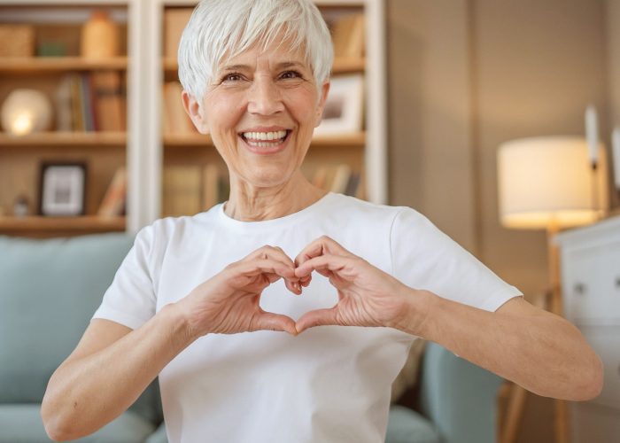 Seniorin Eine Seniorin formt mit ihren Händen ein Herz.